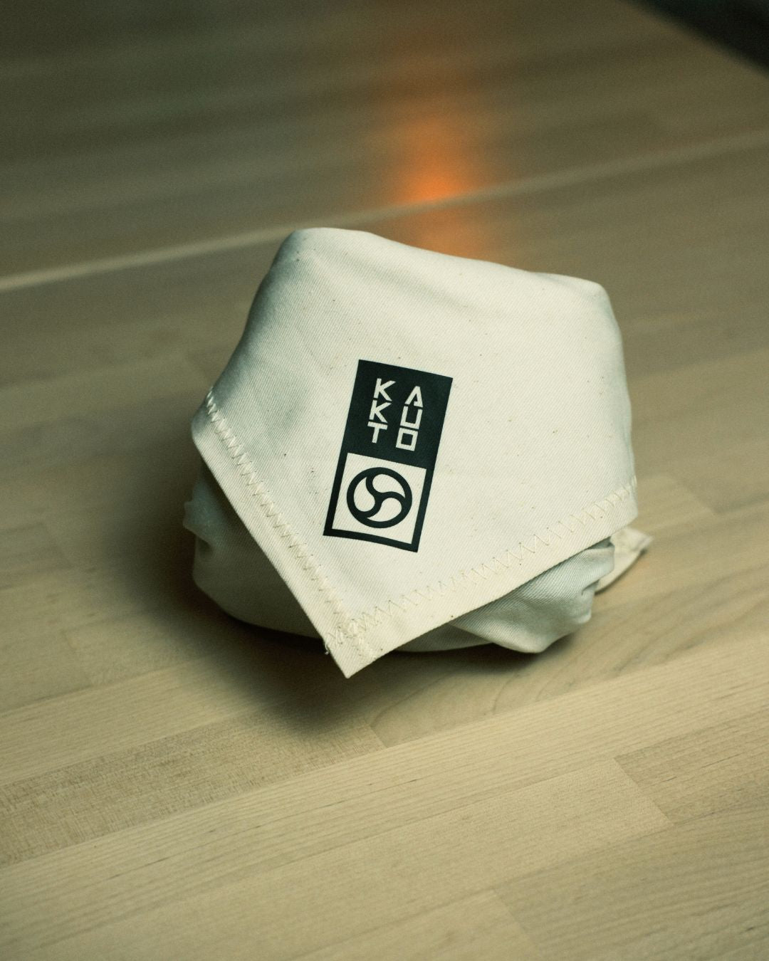 grappler holding 10 pack of finger tape with white finger tape wrapped around his fingers. Grappler is wearing kakuto culture's rashie.